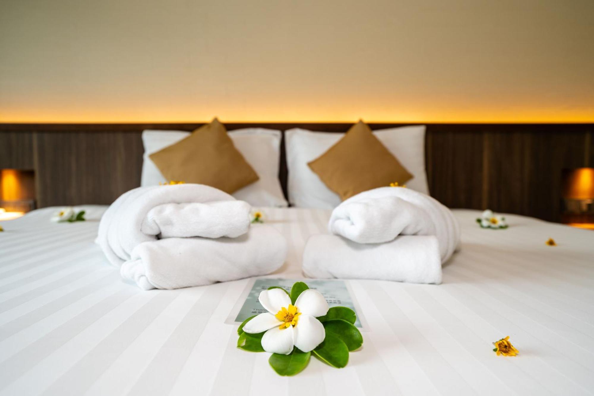 Le Resort&Villas Rawai Esterno foto A bed with towels and flowers